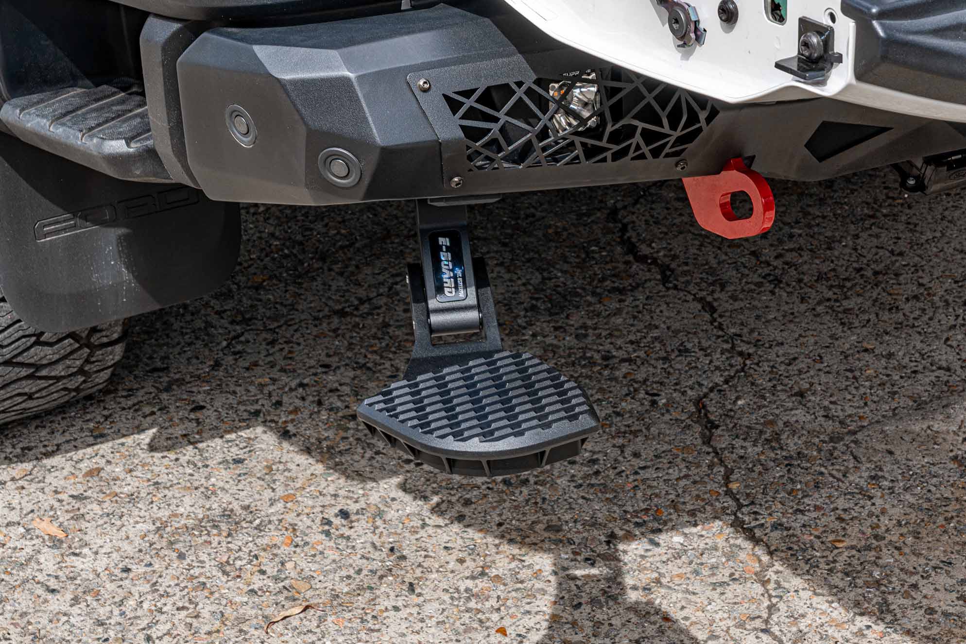 Low angle view of the Supreme Electric Rear Step deployed, showcasing low stepping height and heavy-duty stability.